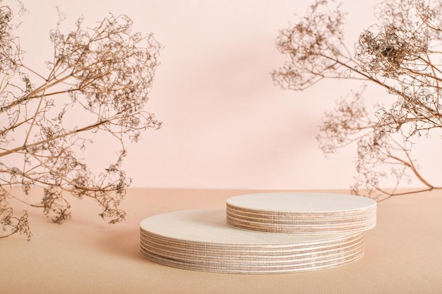 Podium made of two wooden cylinders made of natural wood with dried flowers Minimalistic branding scene