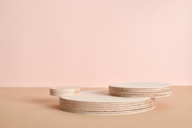 Podium of three wooden cylinders on a beige background Minimalistic branding scene