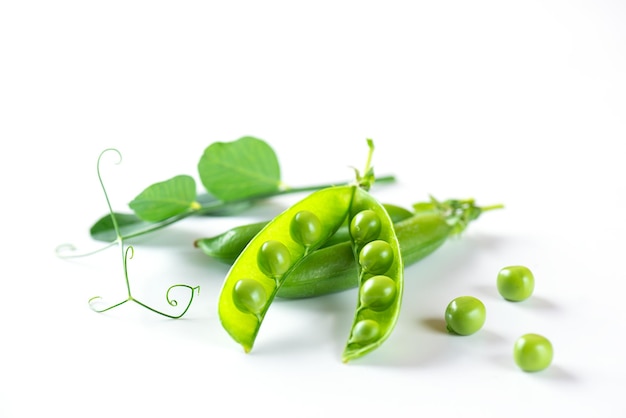 Pods of ripe green peas with leaves on a white background Selective focus