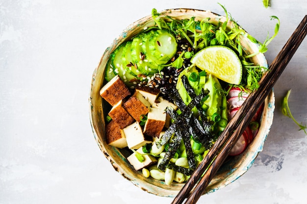 Poke bowl with avocado, black rice, smoked tofu, beans, vegetables, sprouts