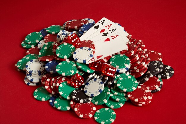 Poker cards and gambling chips on red background. Top view. Copy space. Still life. Flat lay. Cards - four aces. 4 of a kind