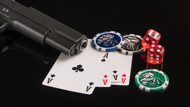 Poker chips cards and a gun on a black background The concept of gambling and entertainment