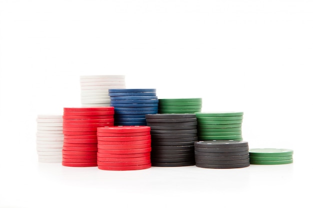 Poker coins piled up together against a white background