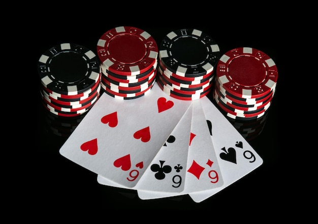 Poker game with four of kind combination Chips and cards on black table Successful and maximum win