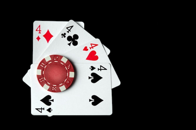 Poker game with quads or four of a kind cards combination Chips and cards on a black table in a poker club Luck or fortune in the play