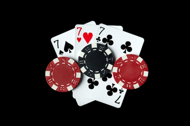 Poker game with three of a kind or set combination Chips and cards on the black table in poker club