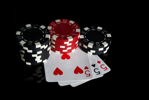 Poker game with three of kind or set combination. Chips and cards on black table. Successful and win. Free advertising space