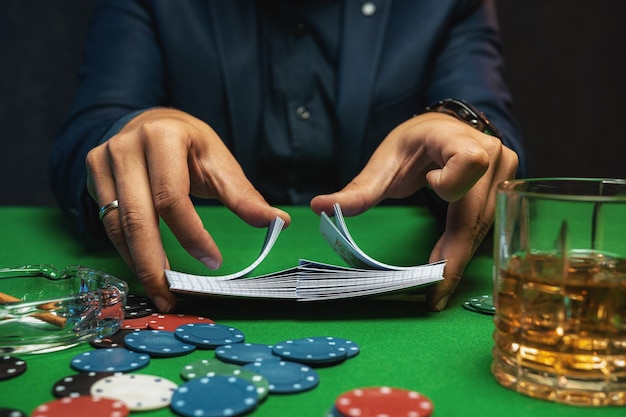 Poker player shuffles the poker cards in casino