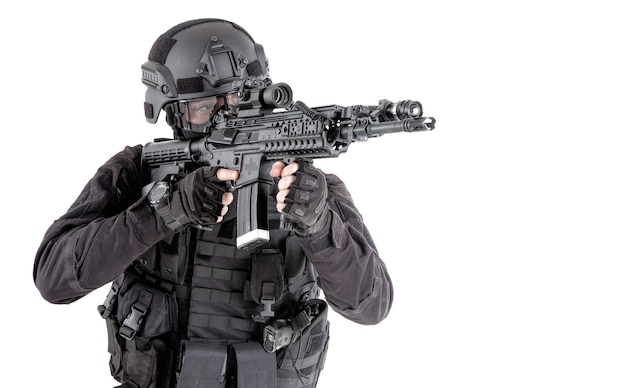 Police special forces, SWAT team fighter in tactical ammunition and armor, aiming weapon, observing suspect movements, controlling sector with optical sight on service rifle isolated studio shoot