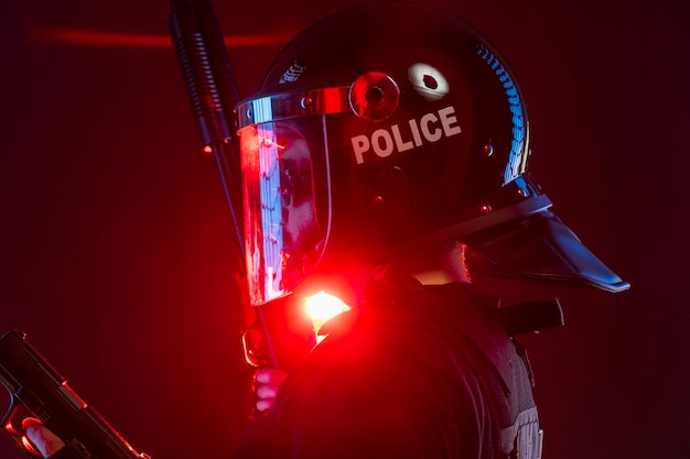 policeman with full equipment for anti-riot, Law enforcer in protective uniform ready for crowd control isolated on black