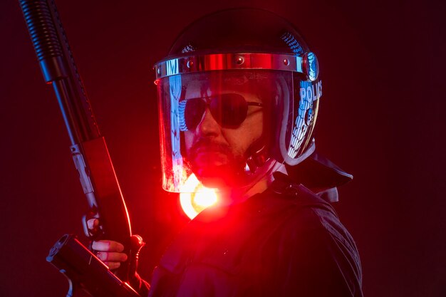 policeman with full equipment for anti-riot, Law enforcer in protective uniform ready for crowd control isolated on black