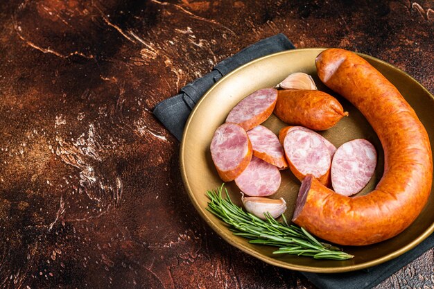 Photo polish smoked sausage in a steel plate dark background top view copy space