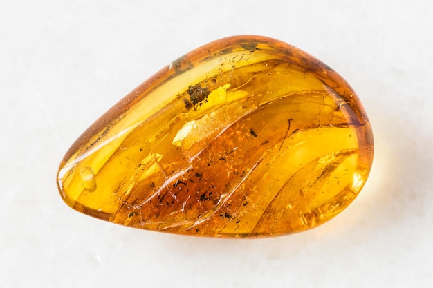 Polished Amber gem stone on white marble