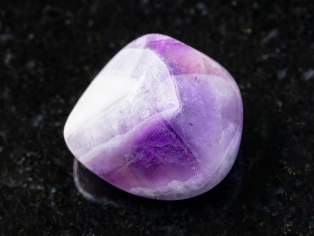 Polished amethyst gem stone on dark background