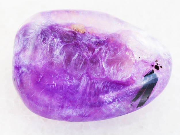 Polished Charoite gemstone on white marble