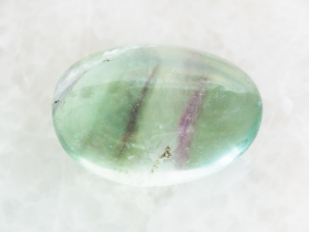 Polished Fluorite gemstone on white marble