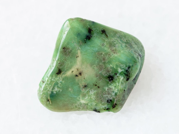 Polished green Grossular garnet gemstone on white