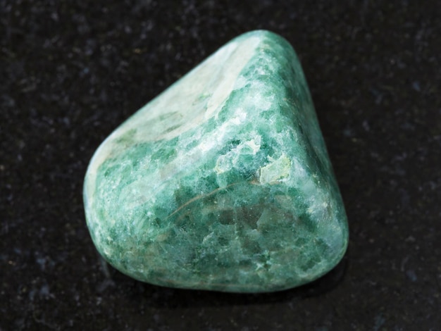 Polished green Jadeite gemstone on dark