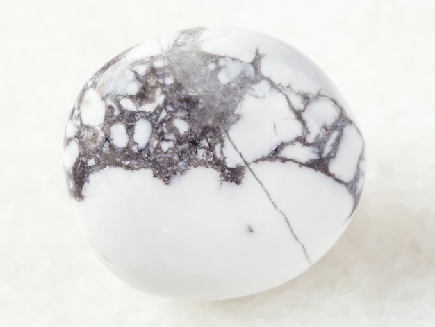 Polished howlite gemstone on white