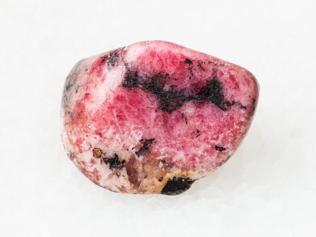 Polished pink rhodonite gem stone on white