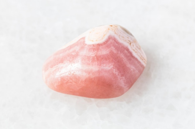 Polished Rhodochrosite rock on white marble