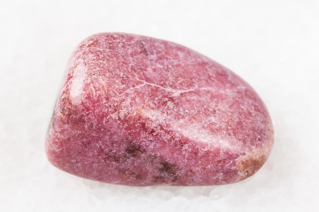 Polished rhodonite gem on white