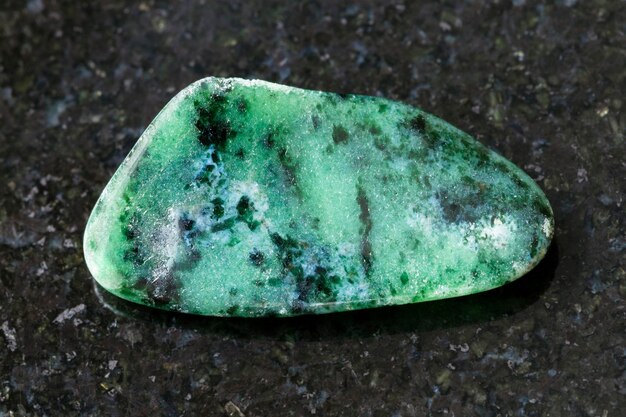 Polished zoisite gemstone on dark background