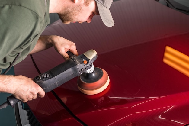 Polishing the body of a red car