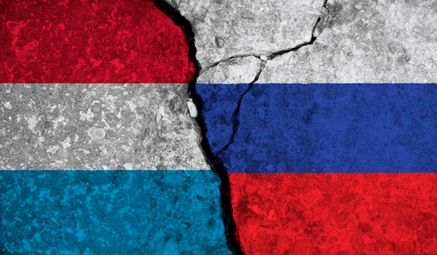 Political relationship between luxembourg and russia national flags on cracked concrete background