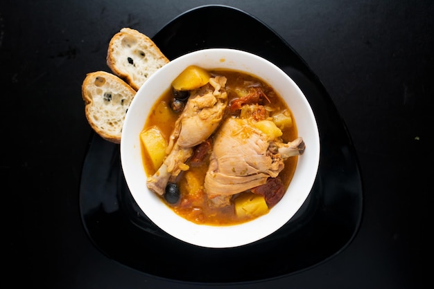 Pollo alla chicken potato with bread served in a dish isolated on dark background top view of italian food