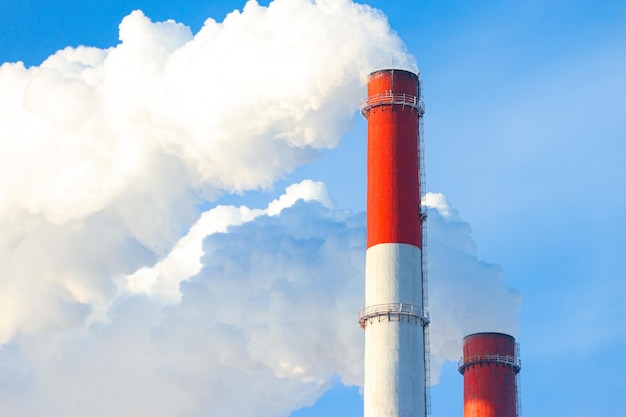 Pollution, emissions - thick smoke is coming out of the pipe into the atmosphere