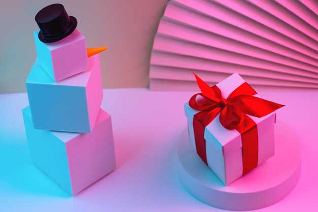 Photo polygonal snowman of cubes and gift illuminated with neon light