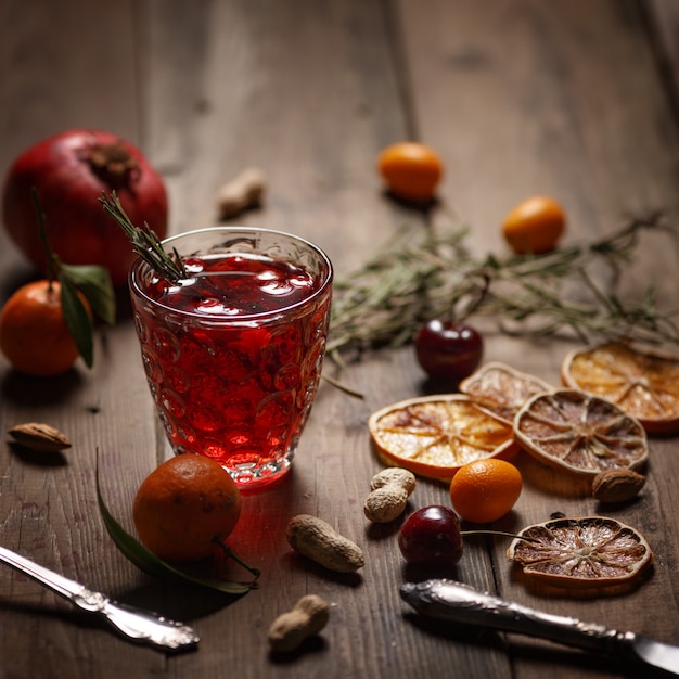 Pomegranate juice with pomegranates and dried fruits on a wooden table. Country style.