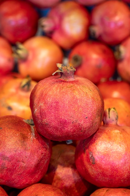 Pomegranate on the market counter Pile of ripe pomegranates