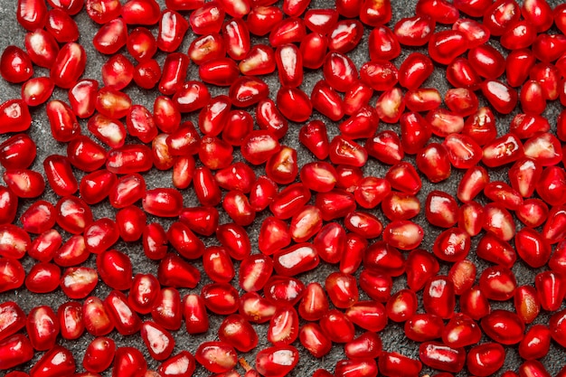 Pomegranate seeds on dark concrete table