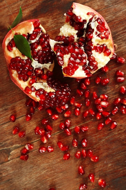 Pomegranate seeds on wooden table closeup