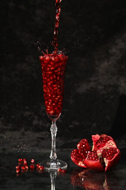 pomegranate wine in the glass on the black background