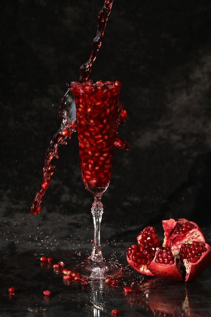 pomegranate wine in the glass on the black background