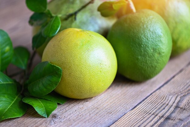 Pomelo fruit on wooden background fresh green pomelo and leaf frome pomelo tree pummelo grapefruit in summer tropical fruit in thailand