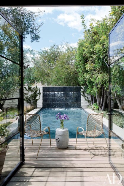 Photo a pool with a fountain and chairs and a water feature