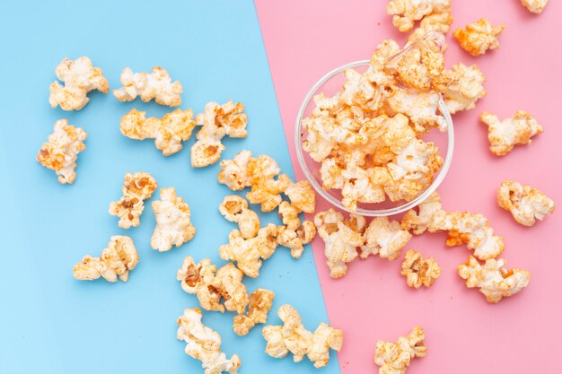 Popcorn in a bowl on blue and pink.