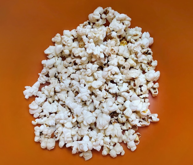 Popcorn food in red bucket. White pop corn delicious snack on the yellow background.