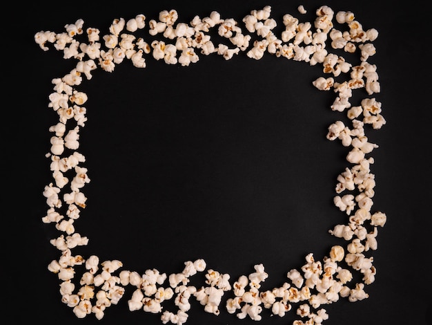 A popcorn frame for a movie theater poster Black background top view place for text