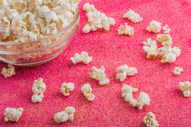 Photo popcorn in a glass plate on a pink background