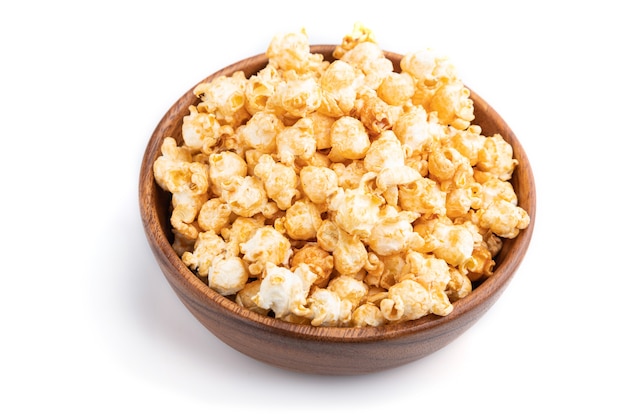 Popcorn with caramel in wooden bowl isolated on white surface