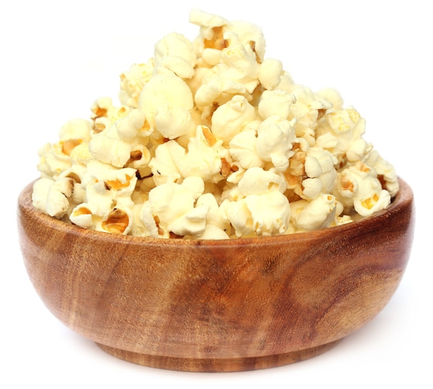 Popcorns on wooden bowl over white background