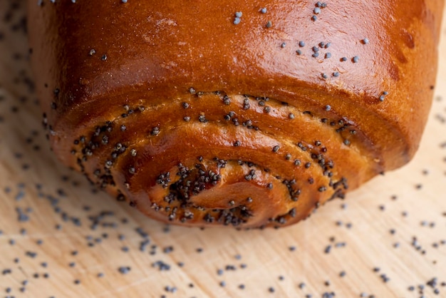 Poppy seeds and a bun with poppy seeds on the table baking with poppy seeds and wheat flour