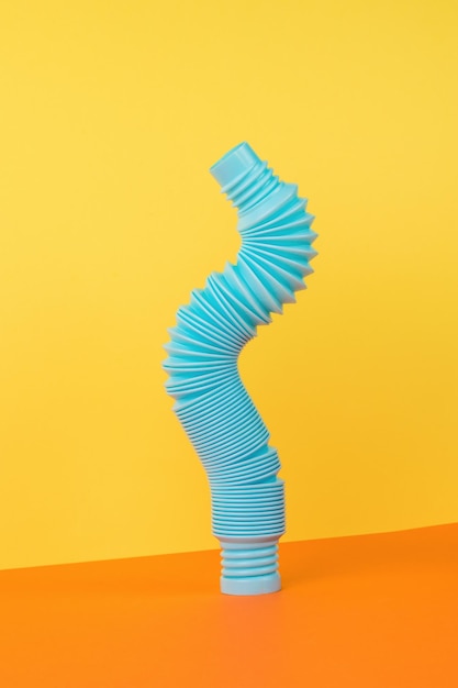 A popular blue tube toy on a yellow and orange background