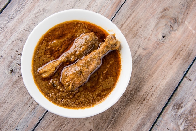 Popular reddish Chicken Curry or Masala, with prominent Leg Piece, served in a bowl