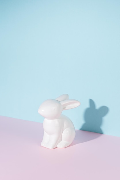 Porcelain Easter bunny or rabbit with sharp shadows on bright background Creative minimal Easter concept